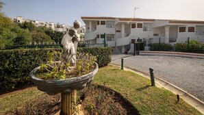 A statue in a garden with a building in the background. - Arte De Luz - Apartment In Calahonda-chaparral (Mijas (mÁlaga), Málaga)