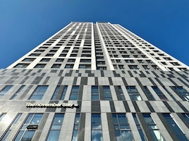 A tall building with a checkered facade and a sign reading "The November Stay".