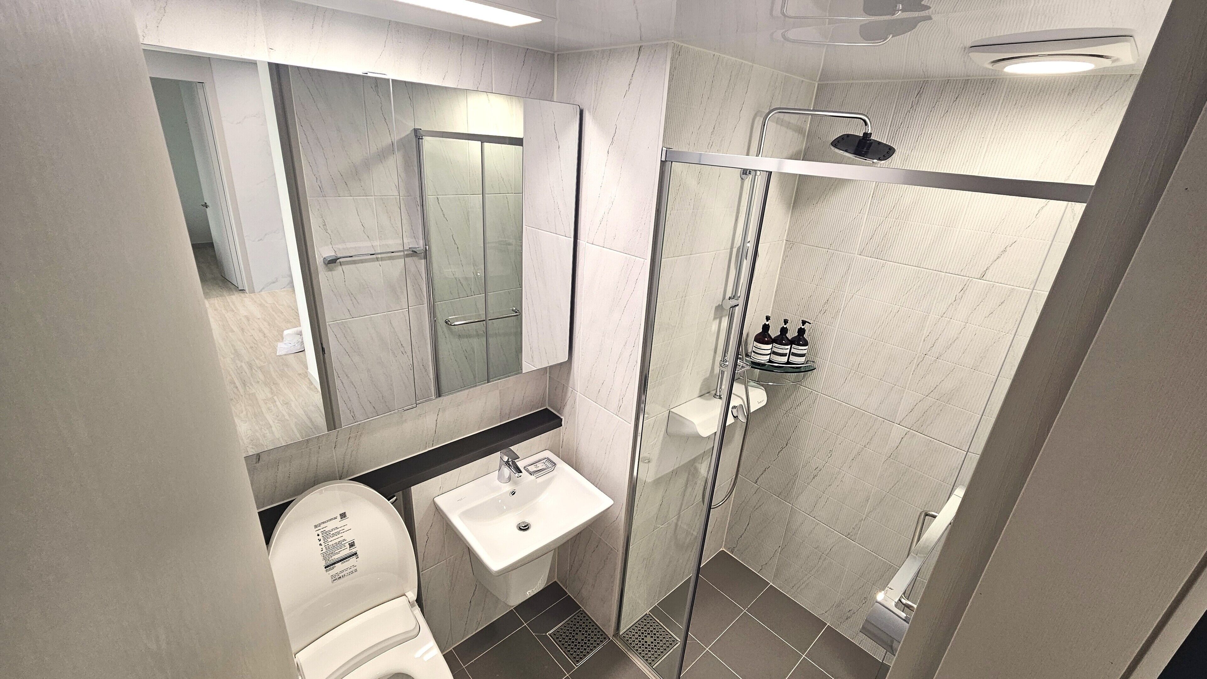 Ein modernes Badezimmer mit Toilette, Waschbecken und einer Duschkabine.