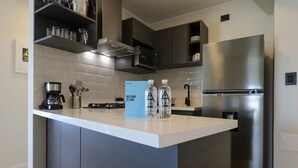 Una cucina moderna con isola centrale, elettrodomestici in acciaio inossidabile e una macchina per il caffè.