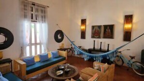 A cozy living room with a hammock, wooden furniture, and a bicycle. - w *| Sensational 4BR House w/ pool in Cartagena (Cartagena de Indias)