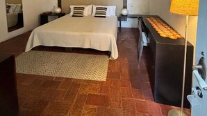 A bedroom with a bed, a ceiling fan, a bedside table, a lamp, and a mirror. - w* |Marvelous 3BR House with pool in Cartagena (Cartagena de Indias)
