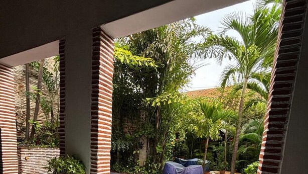 A poolside area with two sun loungers, a small pool, and a view of a garden with palm trees. - w* |Marvelous 3BR House with pool in Cartagena (Cartagena de Indias)