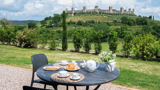 Mesa al aire libre con vistas a un castillo en una colina.