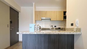 A modern kitchen with wooden cabinets, a granite countertop, and a built-in stove. - w* | Great 2BR Apartment with Balcony in Miraflores (Lima)