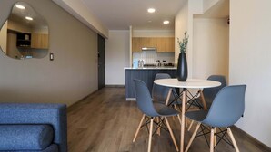 A modern kitchen with wooden cabinets, a white countertop, and a black vase on the island. - w* | Great 2BR Apartment with Balcony in Miraflores (Lima)