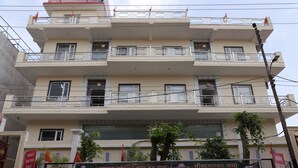 Un immeuble à plusieurs étages, doté de balcons et d’une grande banderole à l’avant.