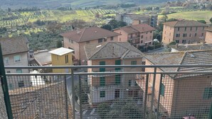 A residential area with terracotta-roofed buildings, a view of rolling hills, and a distant mountain. - Garibaldi 14 Suite (Chianciano Terme)