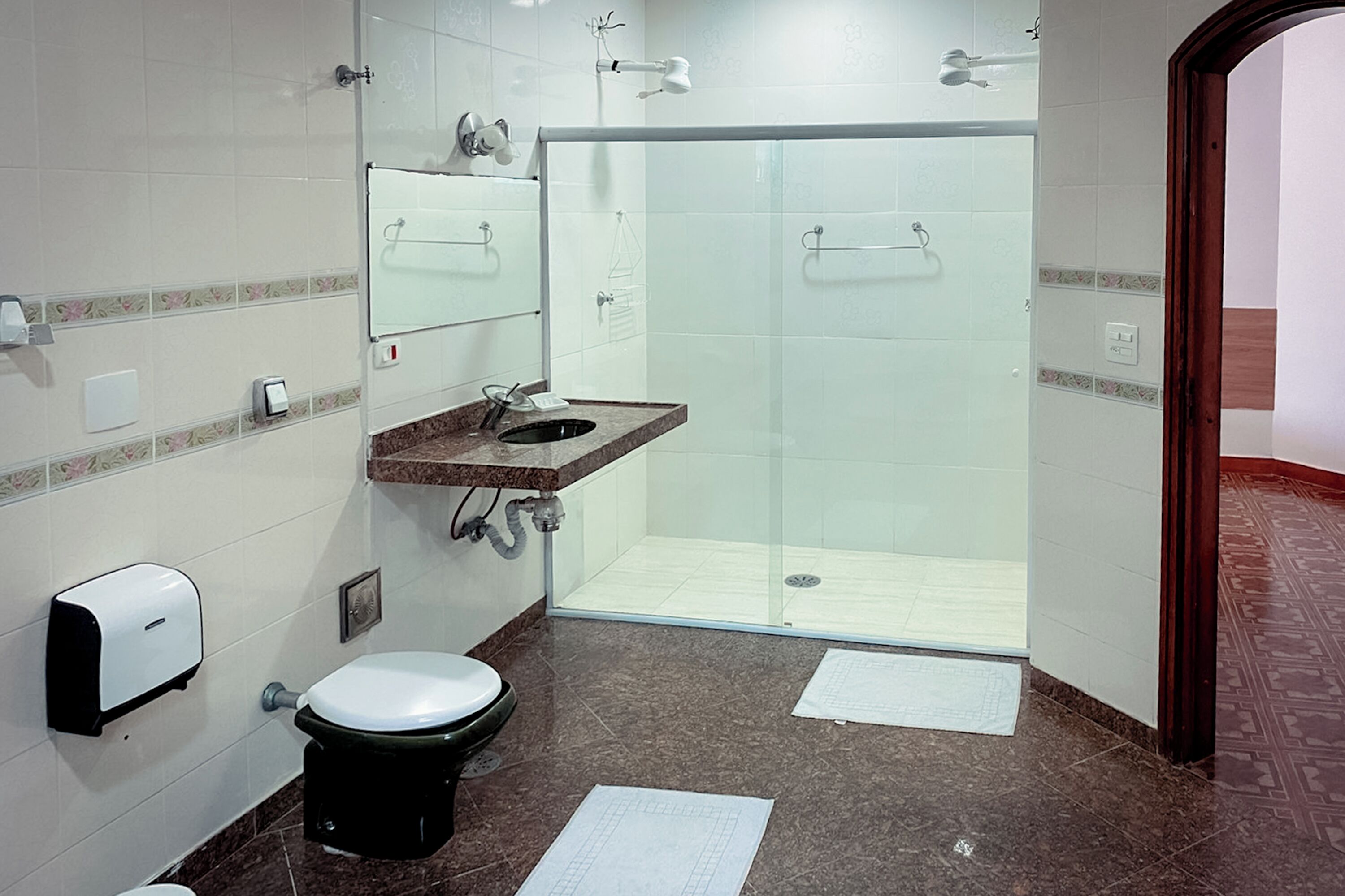 Een moderne badkamer met toilet, wastafel en douche.