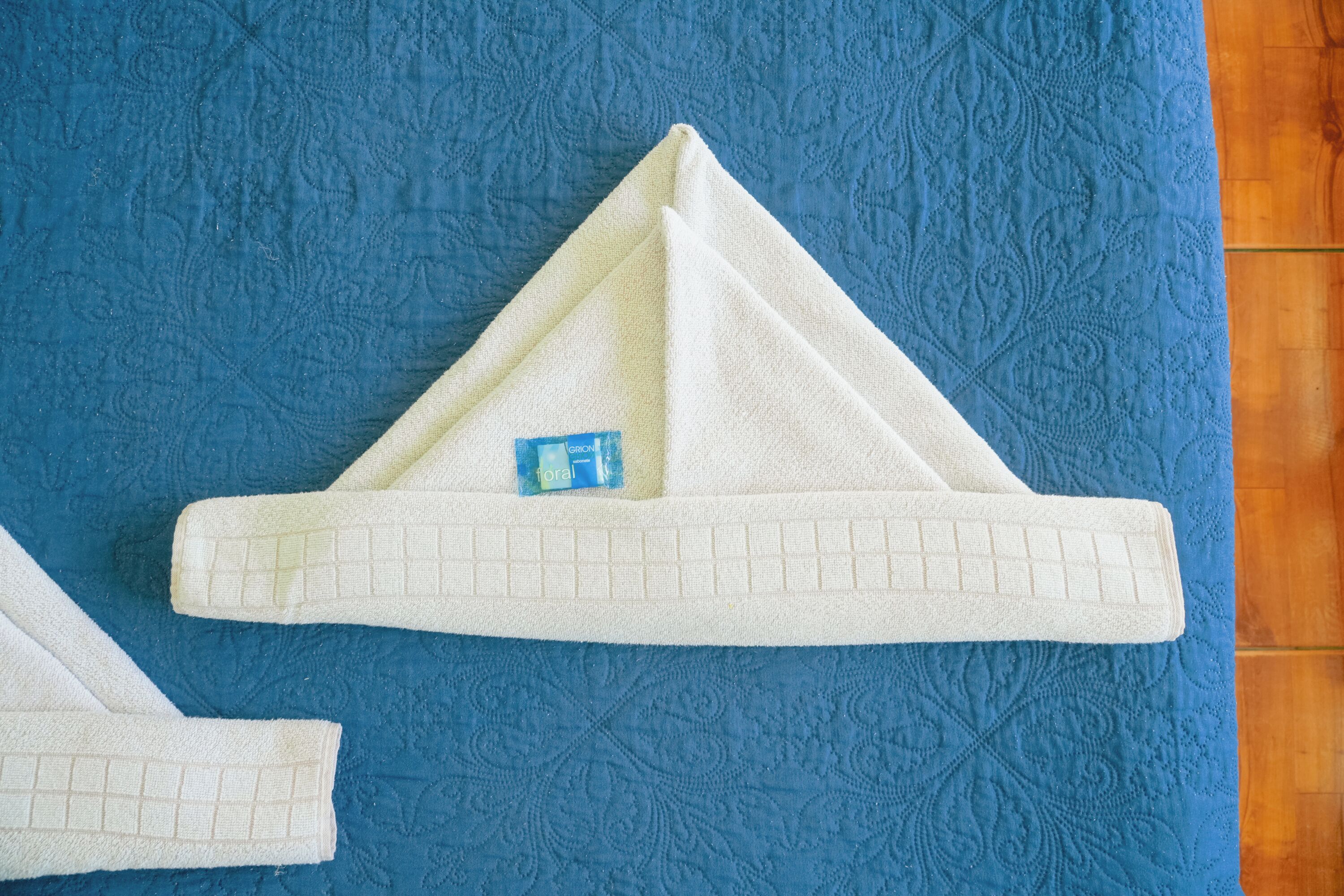 A white towel folded on a blue textured surface.