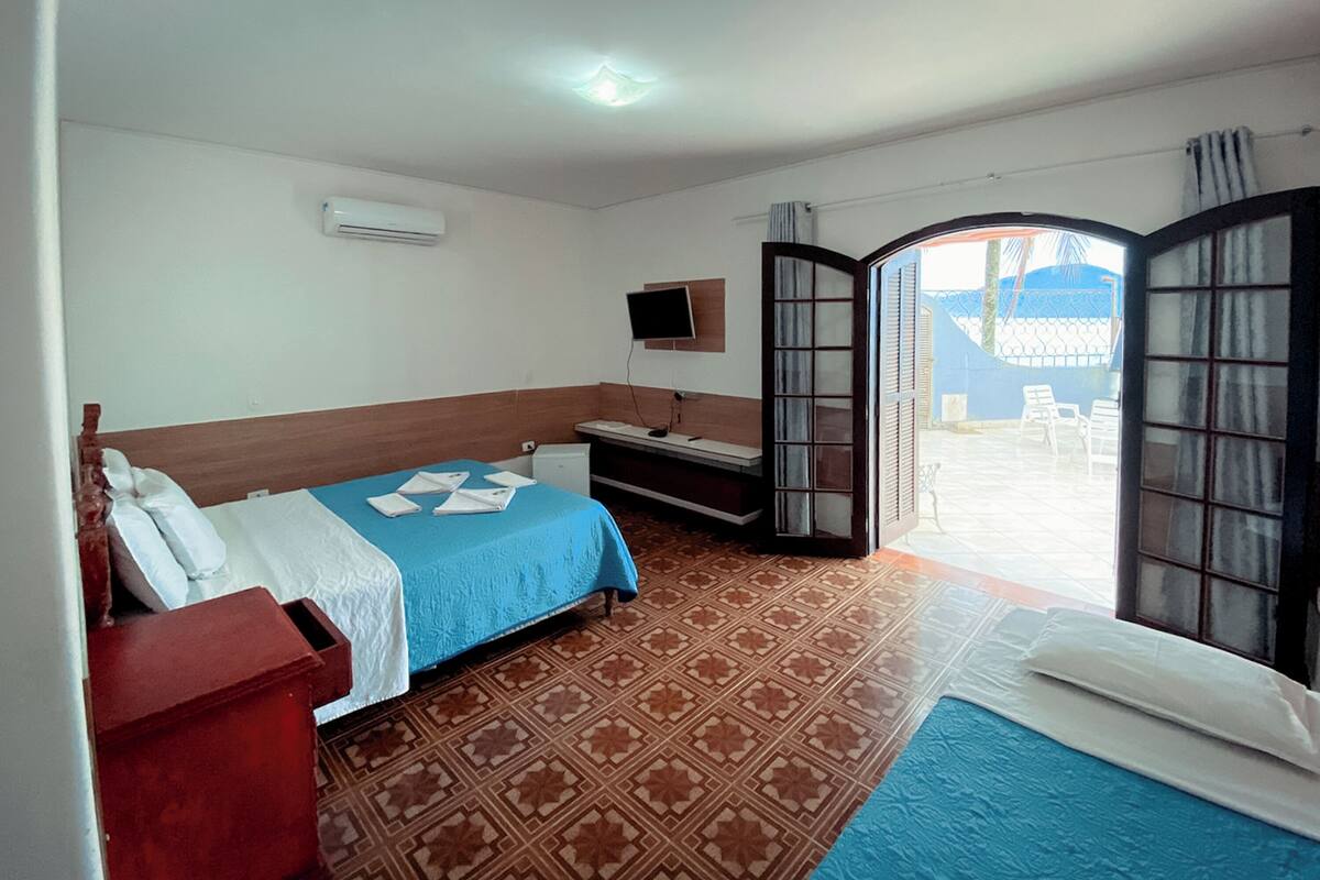 Une chambre d’hôtel avec un lit, un bureau, une télévision et une vue sur l’extérieur.