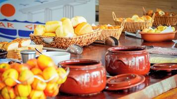 Una mesa de buffet con diversos alimentos y utensilios para servir.