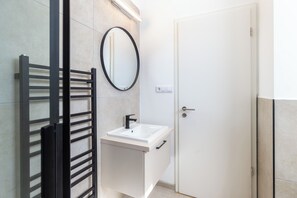 Studio Standar (Nemes Apartment The Petite) | Kamar mandi | Shower, pengering rambut, handuk, dan sabun