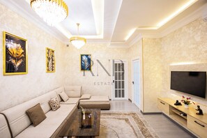 A modern living room with a sofa, coffee table, and TV. - Barokko 31 (Tashkent)