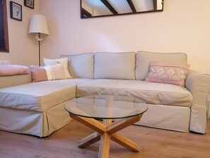 Relax in this stylish living room with a comfortable sofa, coffee table, and wall-mounted mirror.