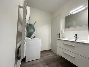 Ein Badezimmer mit Waschbecken, Spiegel und Handtuchhalter.