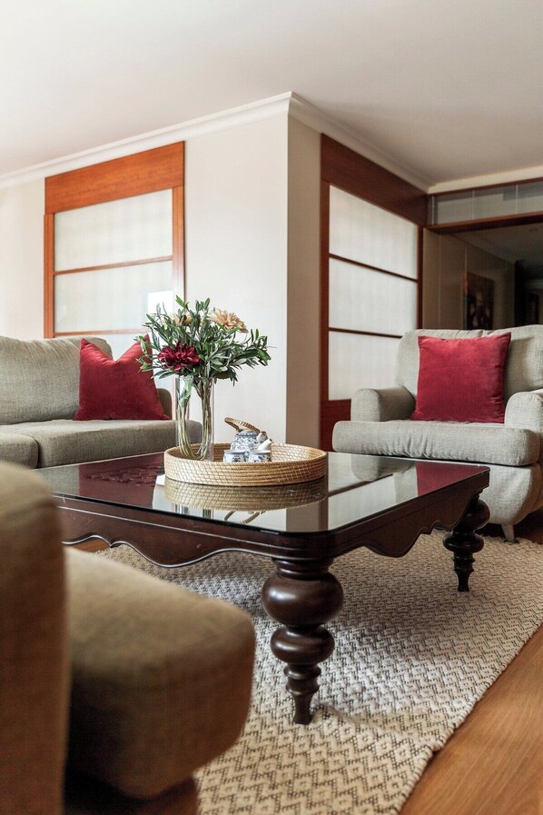 Ein Wohnzimmer mit zwei Sofas, einem Couchtisch und einer Blumenvase.