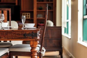Una mesa de comedor con sillas, una copa y un tazón.