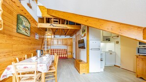 Un chalé acogedor con comedor, cocina y habitación en entrepiso.