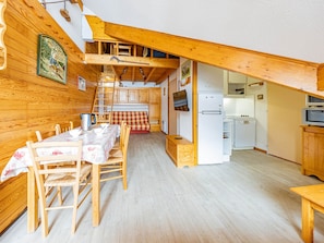Ein gemütliches Chalet mit Essbereich, Küche und Schlafzimmer auf dem Dachboden.