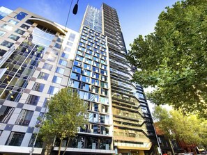 Un immeuble moderne de grande hauteur, doté de nombreux étages, de grandes fenêtres et d’une façade combinant verre et métal.