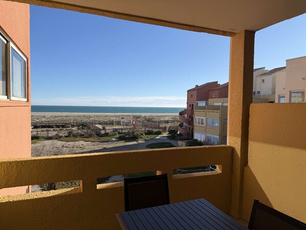 A balcony with a view of the beach and adjacent buildings. - Port Leucate: AC 1BR, 4 pers, parking, near beach (Port Leucate)