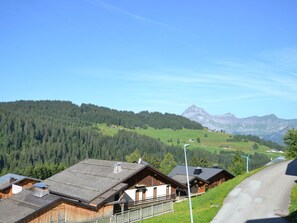 A rural mountain village with wooden buildings, a road, and a mountain in the background. - Modern apartment near slopes, 6 pers, south balcony, pets allowed, parking, wifi (Notre-Dame-de-Bellecombe)