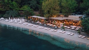 Un bateau était amarré à un quai, avec un restaurant et une plage en arrière-plan.