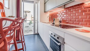 A modern kitchen with white cabinets, a red brick backsplash, and a stainless steel sink. - Trastevere 319 in Rome (Rome)