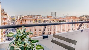 A balcony with a view of a cityscape, featuring buildings and a clear sky. - Trastevere 319 in Rome (Rome)