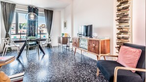A modern living room with a dining area, a TV, and a bookshelf. - Trastevere 319 in Rome (Rome)