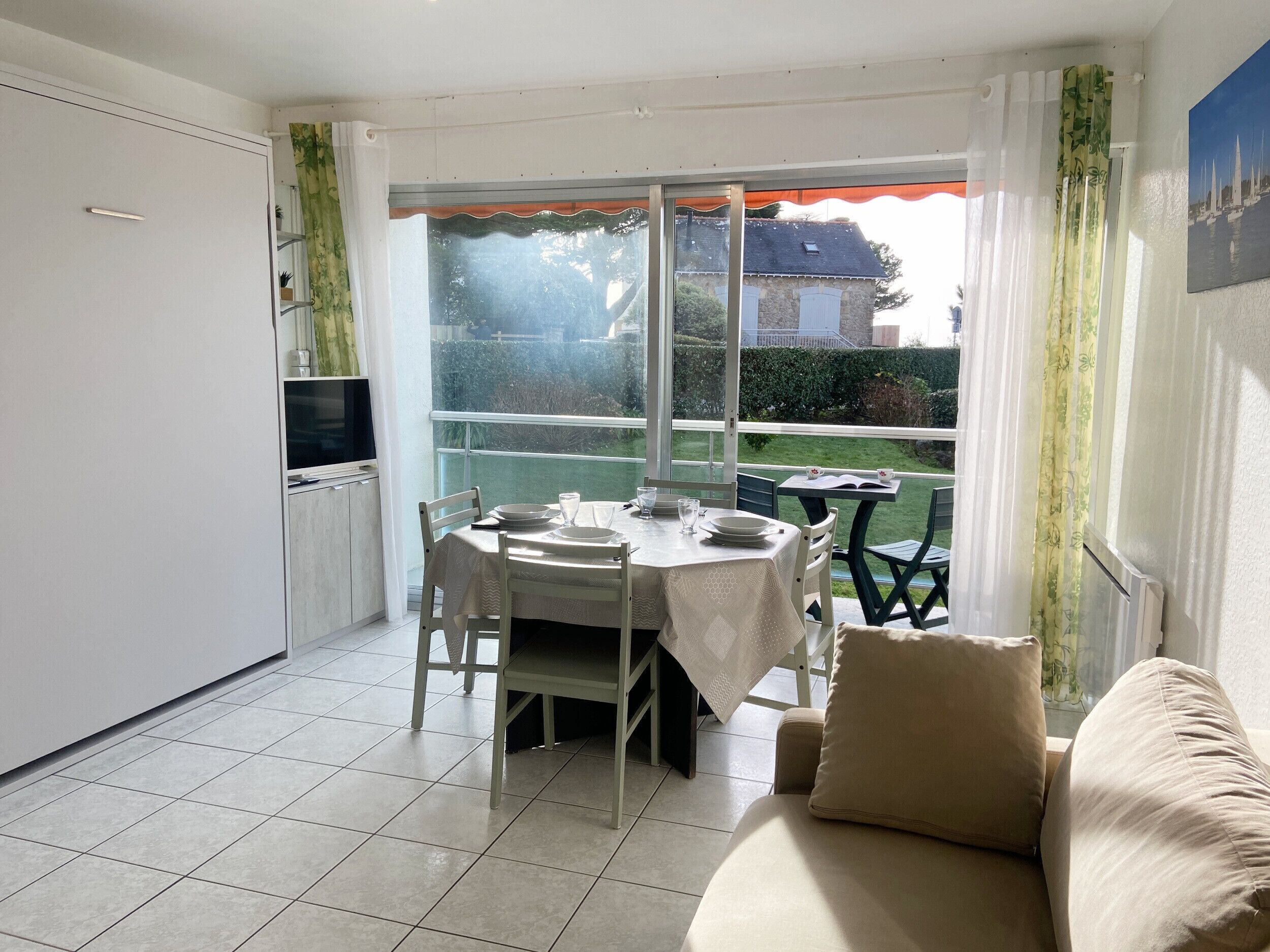 A compact living space with a dining area, kitchenette, and a sofa.