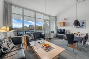 Ein modernes Wohnzimmer mit Sofa, Couchtisch und Essbereich.