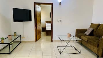 Suite Deluxe, balcón, vistas a la ciudad | Zona de estar | Smart TV de 43 pulgadas con canales por cable