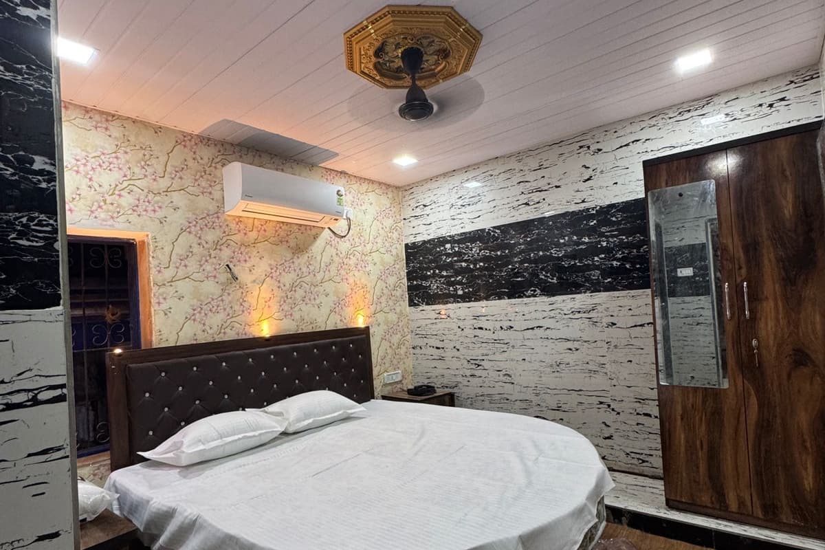 A bedroom with a round bed, a wooden wardrobe, and a ceiling fan.