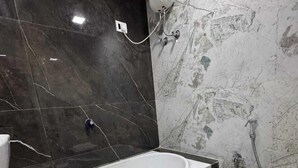 A modern bathroom with a large bathtub, a toilet, and a shower area. - Hotel The Sunset Avenue (Mumbai)