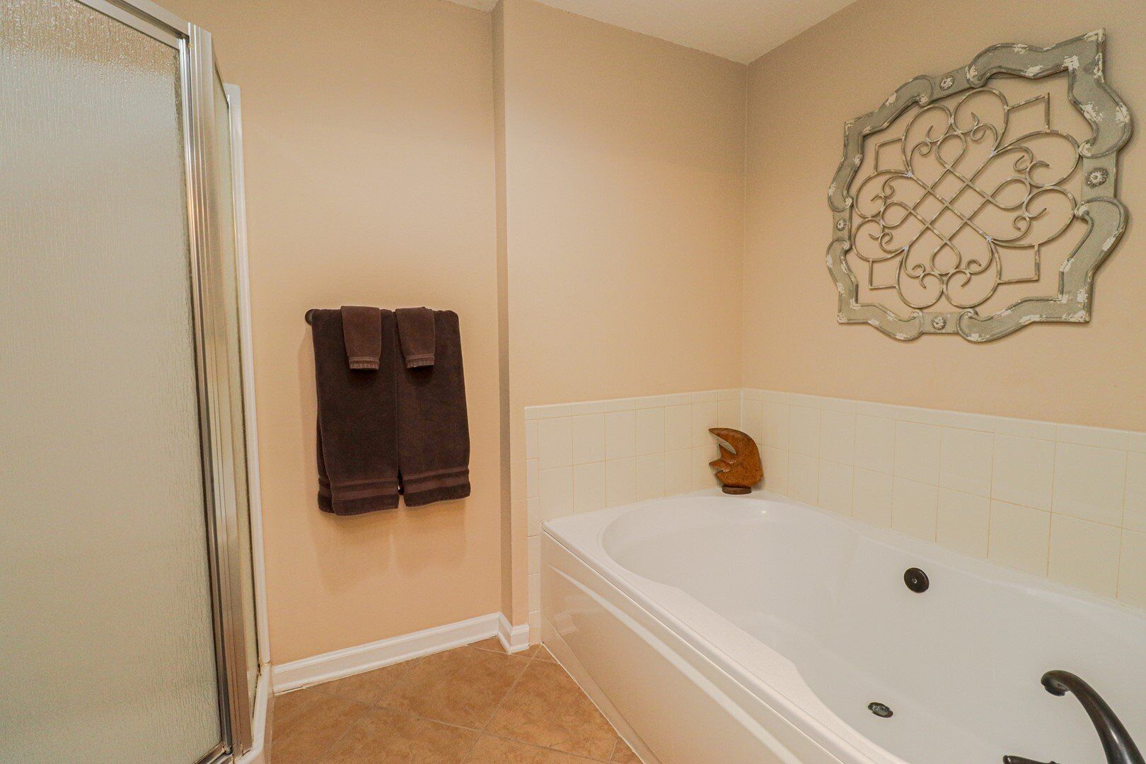 A bathroom with a bathtub, a shower, and two towels hanging on the wall.