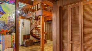 A wooden staircase leading to a second floor, a closed wooden door, and a wicker basket on the floor. - Puzzle Point Lodge in Poulsbo (Poulsbo)