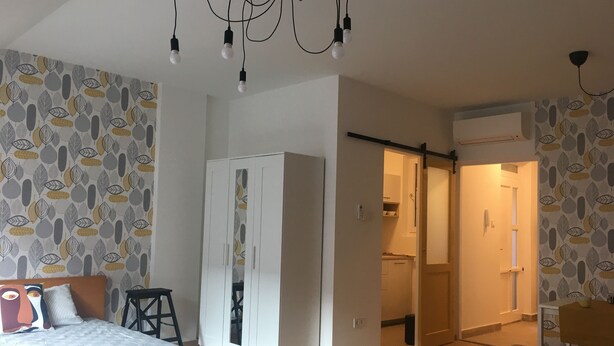 A bedroom with a bed, wardrobe, and a desk. - Cozy studio in beautiful Budapest with WiFi, AC (Budapest)