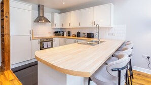 A modern kitchen with white cabinets, a wooden countertop, and a built-in stove. - Hallgarth Street  (Sherburn Village)
