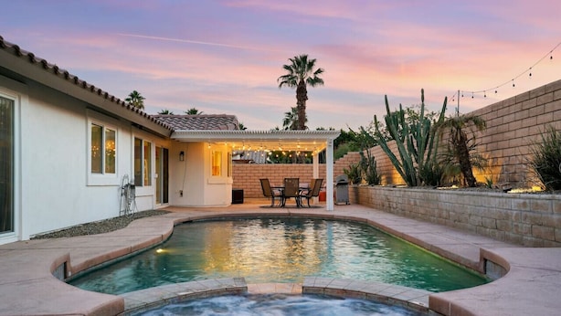 A swimming pool with a hot tub, patio furniture, and a covered seating area. - Villa Solana: Heated Pool, Putting Green, Games (La Quinta)