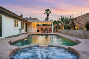 A swimming pool with a hot tub, patio furniture, and a covered seating area. - Villa Solana: Heated Pool, Putting Green, Games (La Quinta)