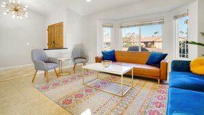 A living room with a sofa, two armchairs, a coffee table, and a patterned rug. - Villa Solana: Heated Pool, Putting Green, Games (La Quinta)