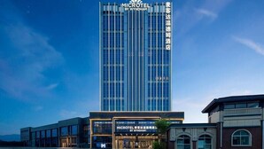 Un hôtel moderne, avec une enseigne bien visible indiquant « MICROTEL BY WYNDHAM » et des caractères chinois.