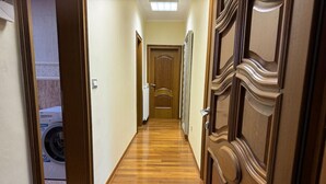 Un corridoio con pavimento in legno e una porta decorata con elaborate incisioni.