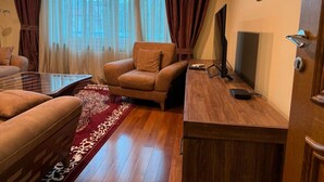 Un soggiorno con divano, poltrona e tavolino in legno.