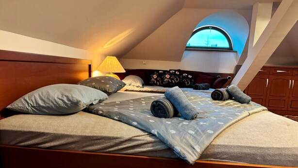 Ein Schlafzimmer mit einem großen Bett, einer Lampe und einem Fenster mit Blick.