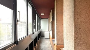 Ein Korridor mit gemustertem Boden, großen Fenstern und einer roten Decke.
