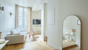 Un salon moderne avec un canapé, une table basse et un téléviseur.