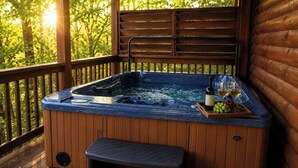 Un jacuzzi con terraza de madera, un banco de madera y una bandeja con vino y uvas.